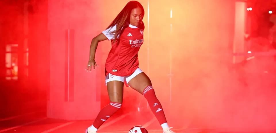 Jugadora de fútbol en camiseta de Arsenal con balón