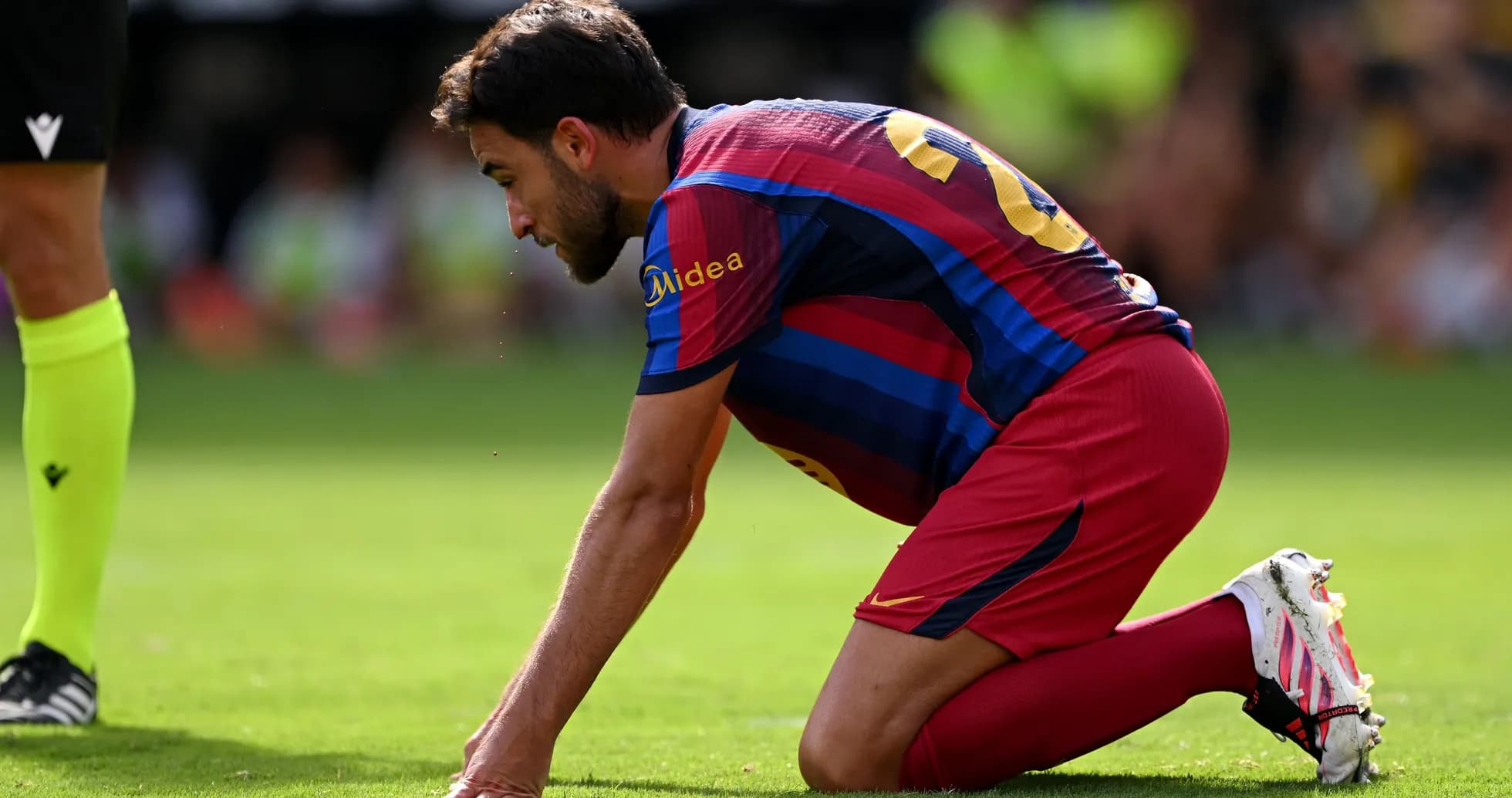 Jugador de Barcelona arrodillado en el campo