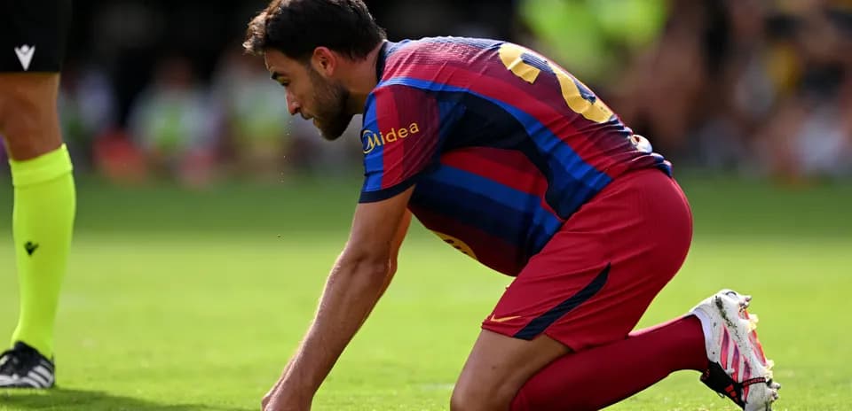 Jugador de Barcelona arrodillado en el campo