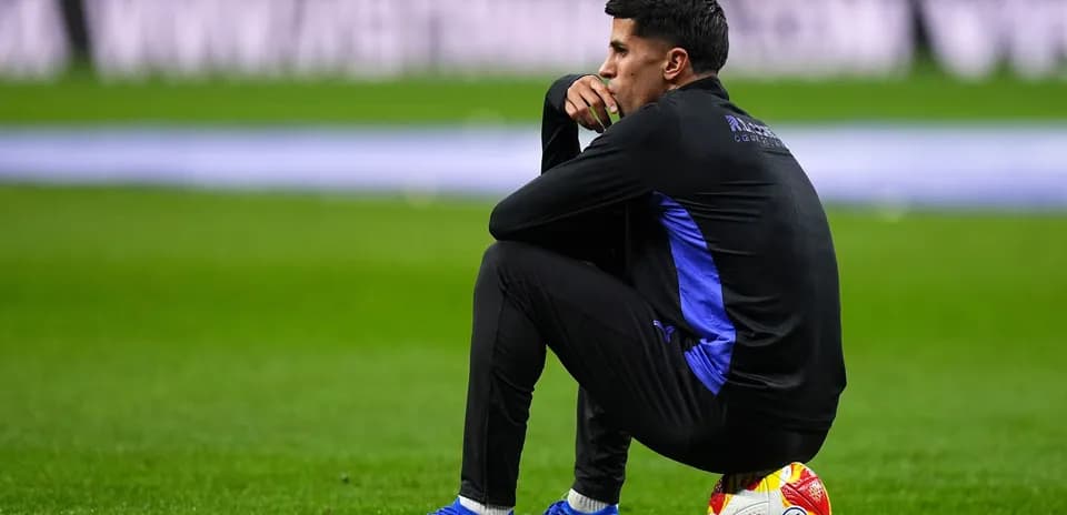 Entrenador sentado en el campo con balón