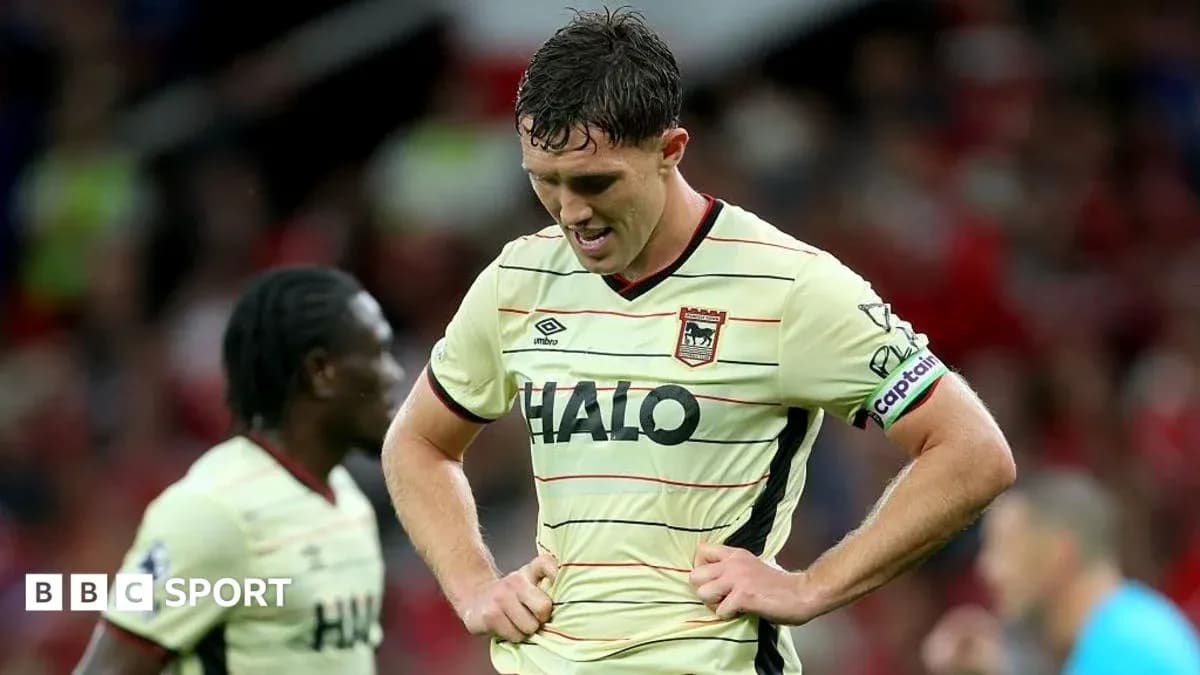 Jugador con camiseta de visitante, cabeza baja en el campo