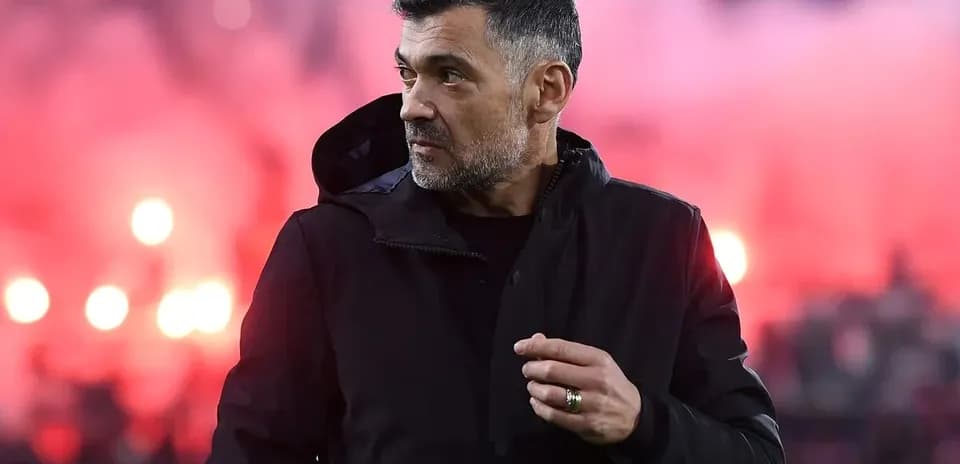 Entrenador observando el partido con humo de fondo