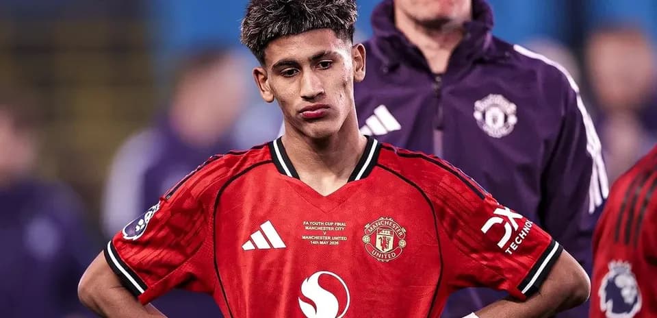 Jugador de Manchester United con camiseta roja, pensativo