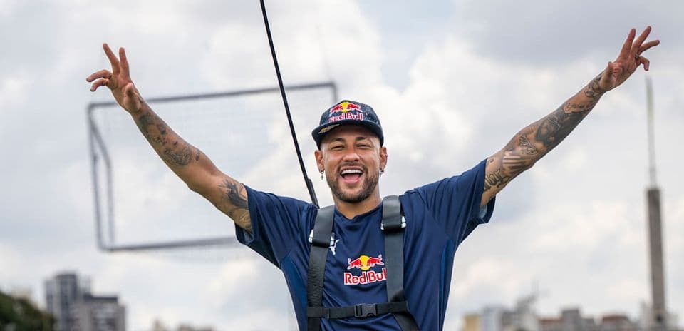 Neymar sonriendo con los brazos levantados en evento