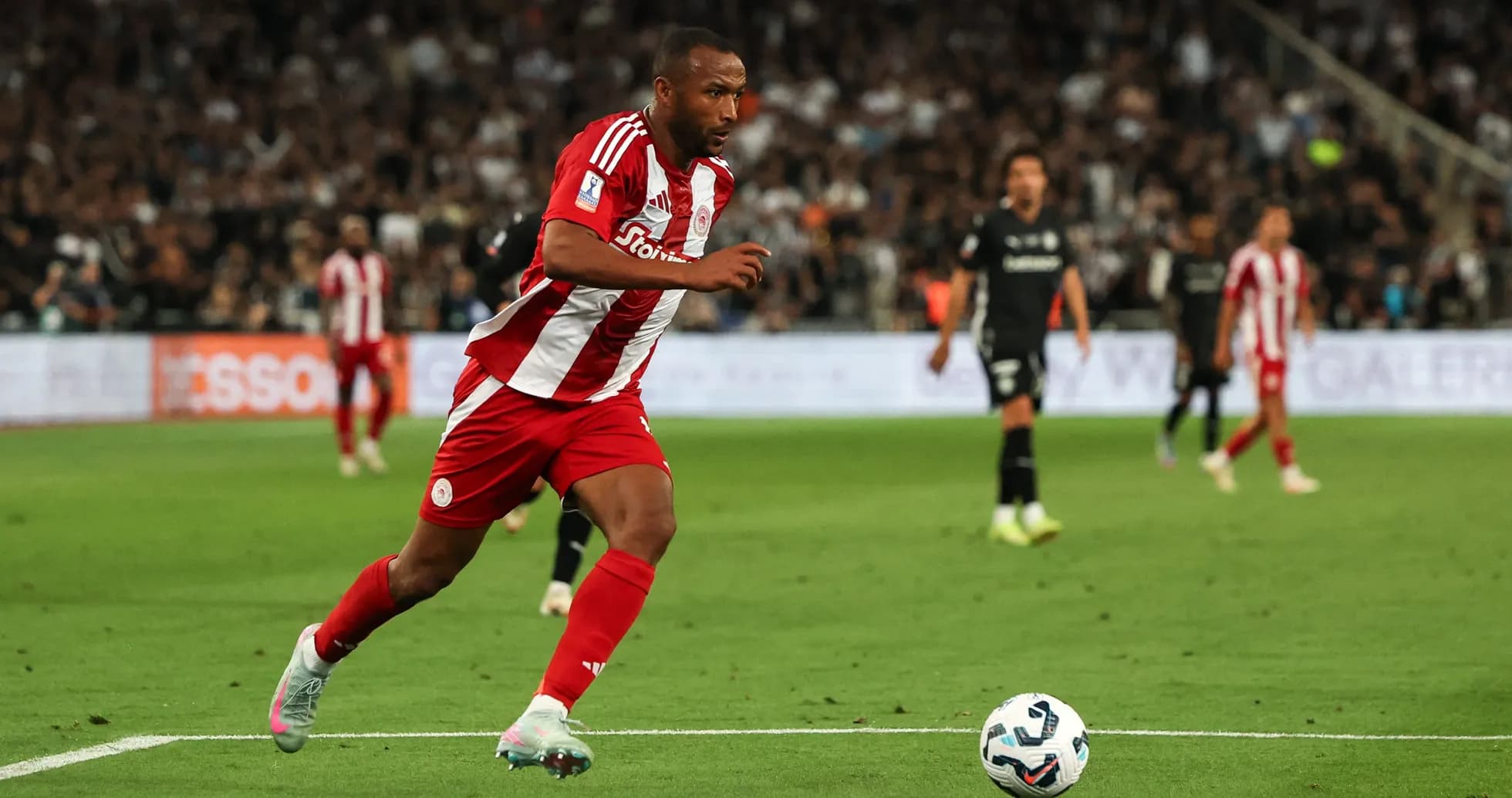 Jugador de Olympiakos corriendo hacia el balón en el campo