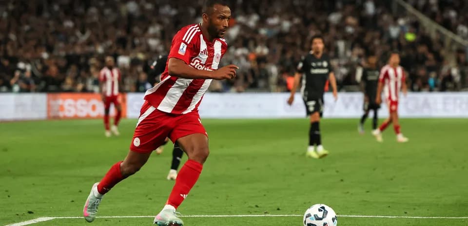 Jugador de Olympiakos corriendo hacia el balón en el campo