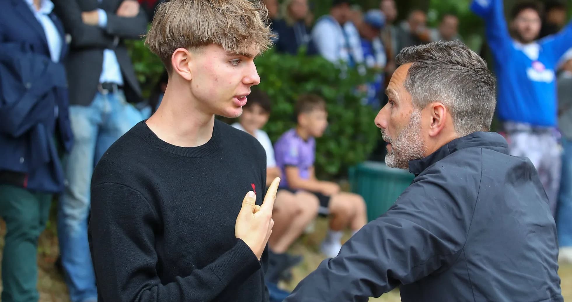 Joven conversando con un hombre en un evento deportivo