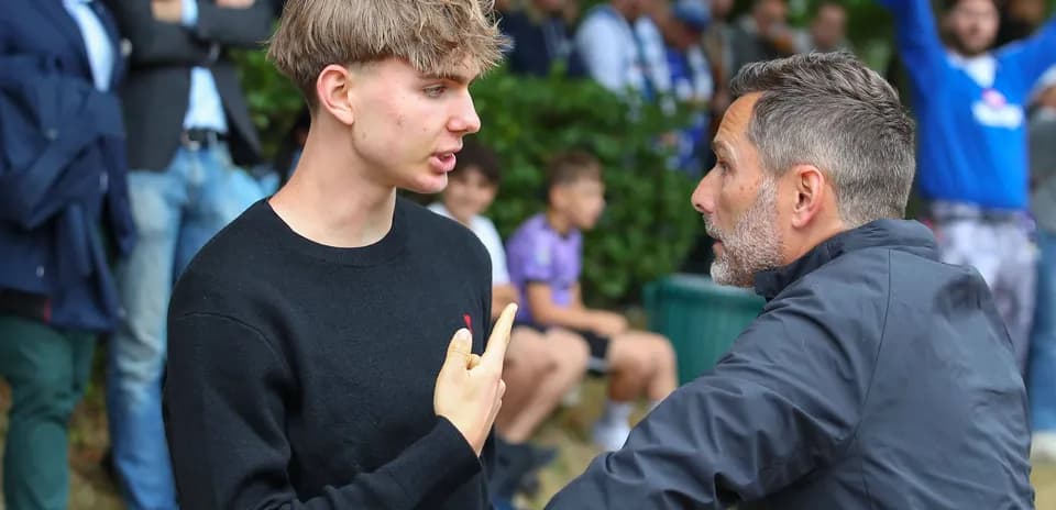 Joven conversando con un hombre en un evento deportivo