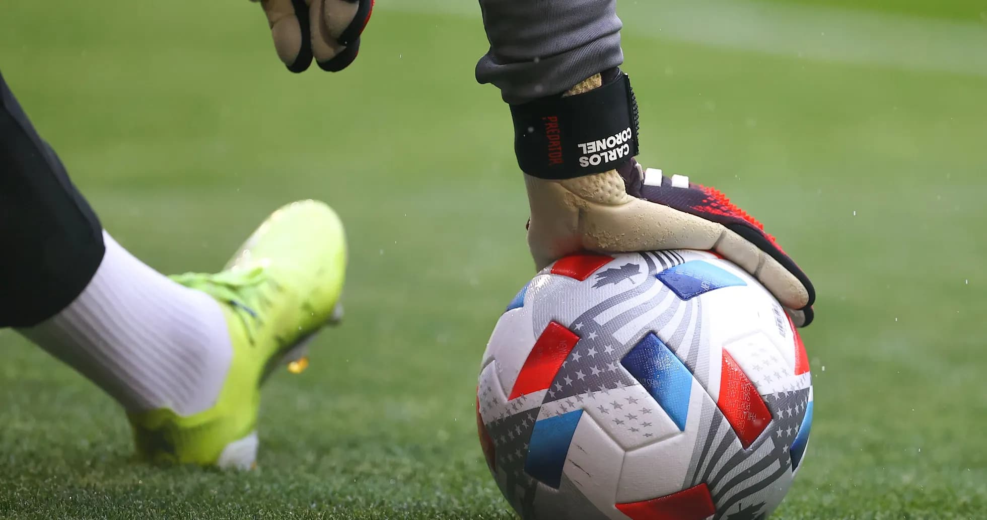 Portero sosteniendo un balón de fútbol en el campo