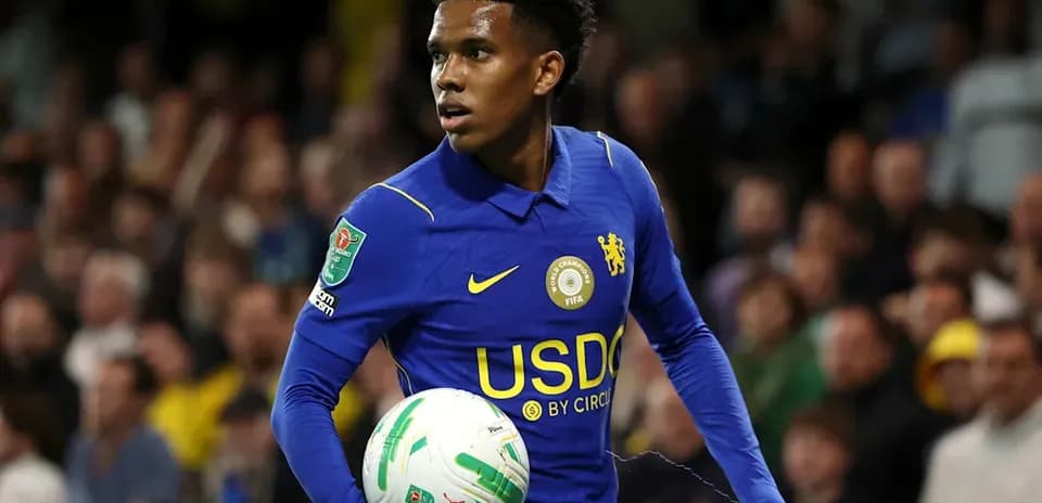 Jugador de Chelsea sosteniendo un balón en el campo