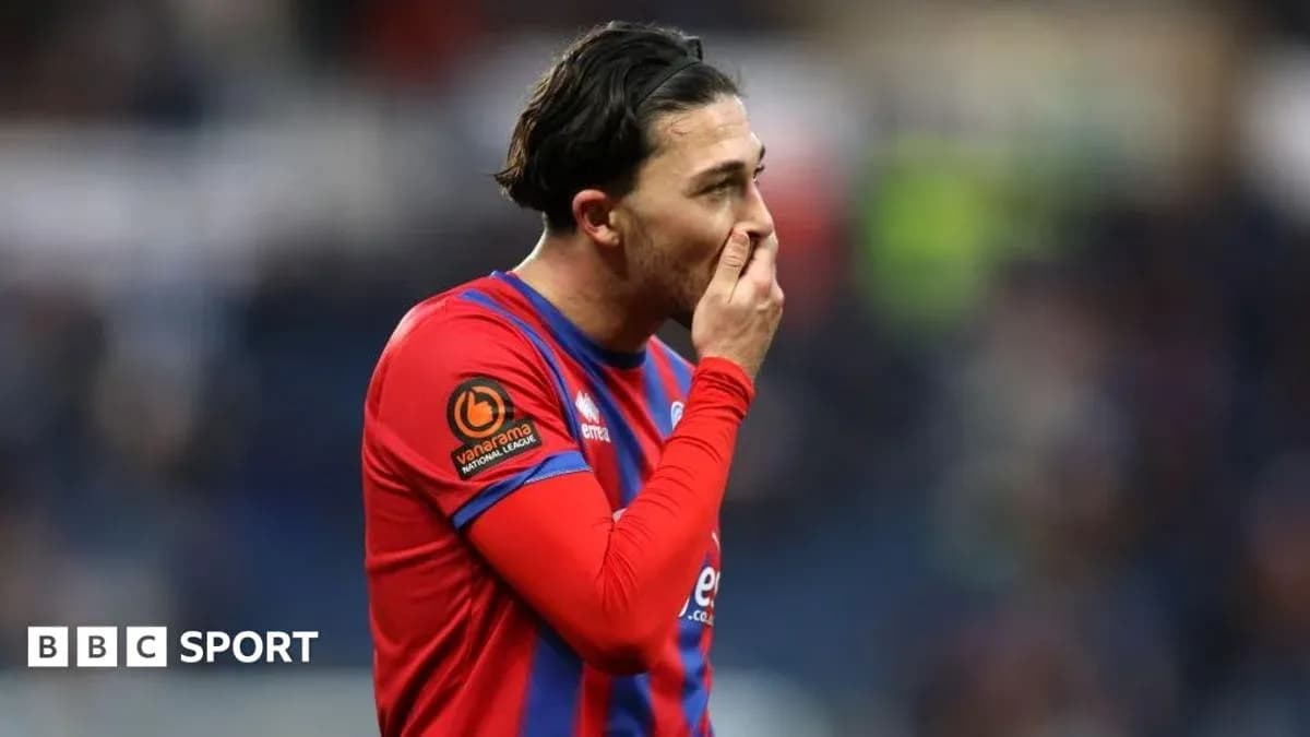 Jugador con camiseta roja tocándose la boca