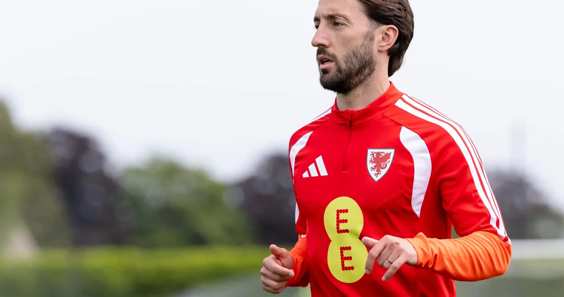 Jugador entrenando en camiseta roja con insignia