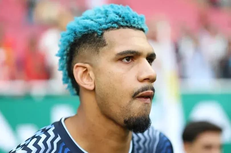 Portero con cabello azul en el campo