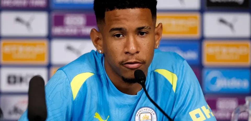 Jugador en conferencia de prensa con camiseta de Manchester City