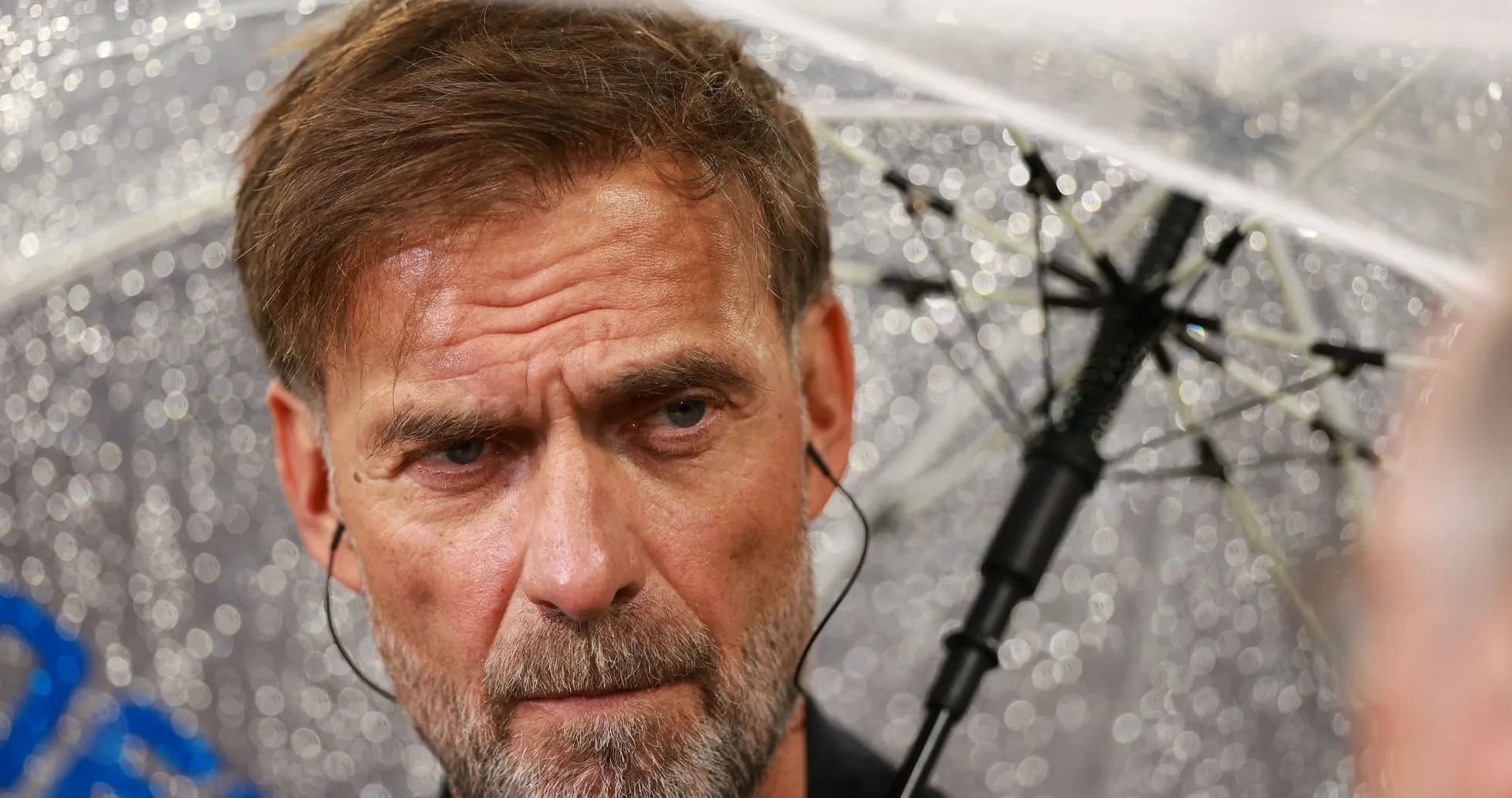 Entrenador bajo un paraguas durante la lluvia