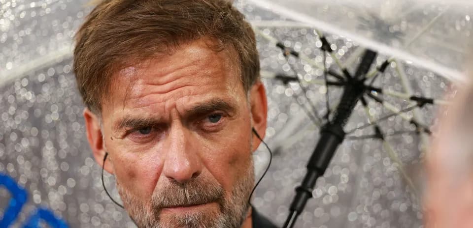 Entrenador bajo un paraguas durante la lluvia