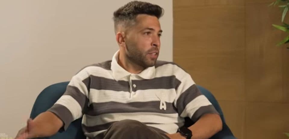 Hombre sentado en un sillón hablando durante entrevista