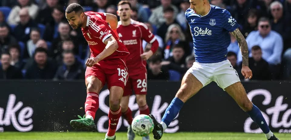 Jugador de Liverpool driblando frente a rival de Everton
