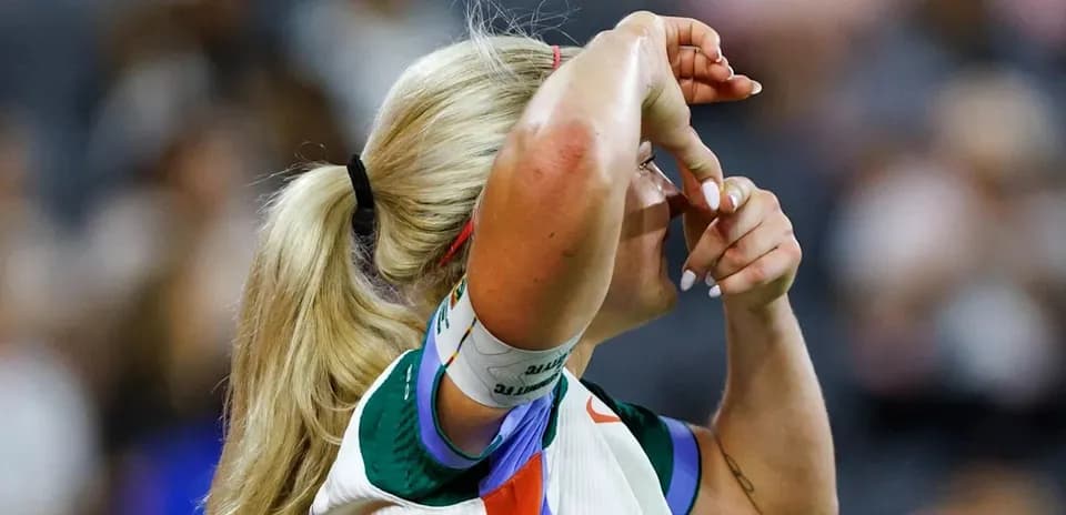 Jugadora de tenis ajustando su cabello durante el partido