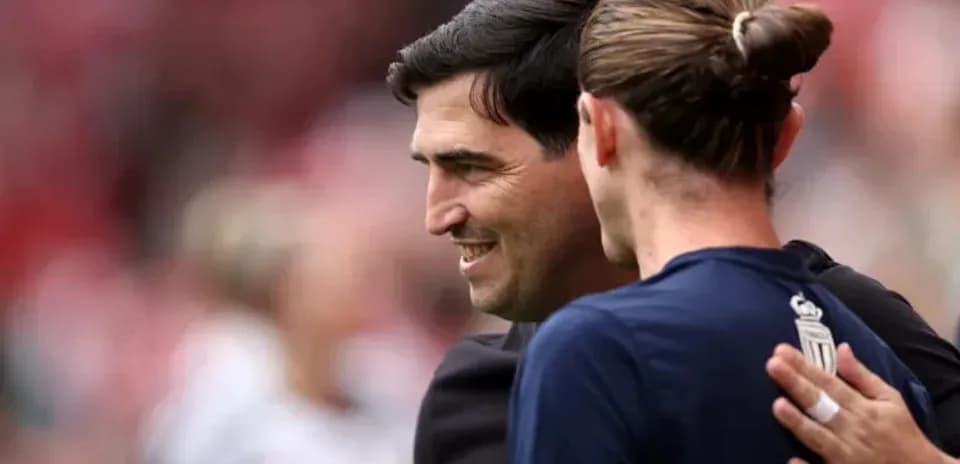 Entrenador y jugador saludándose antes del partido