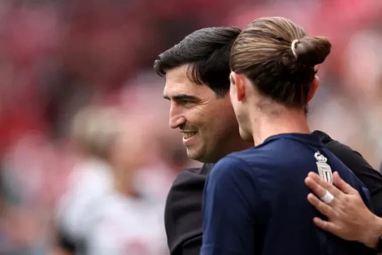 Entrenador y jugador saludándose antes del partido