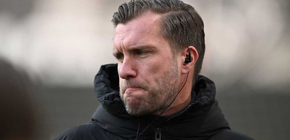 Entrenador con auriculares en el campo de entrenamiento