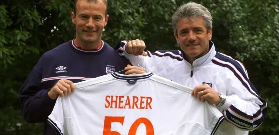 Dos hombres sosteniendo camiseta con el nombre Shearer