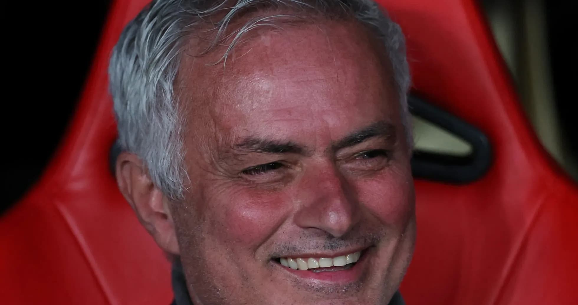 Entrenador sonriente en el banquillo durante el partido