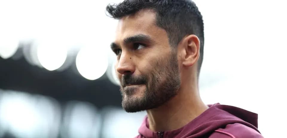 Jugador con chaqueta marrón en el estadio