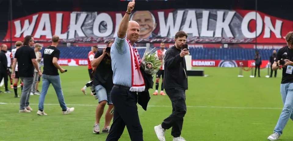 Director saludando con ramo en el campo de fútbol