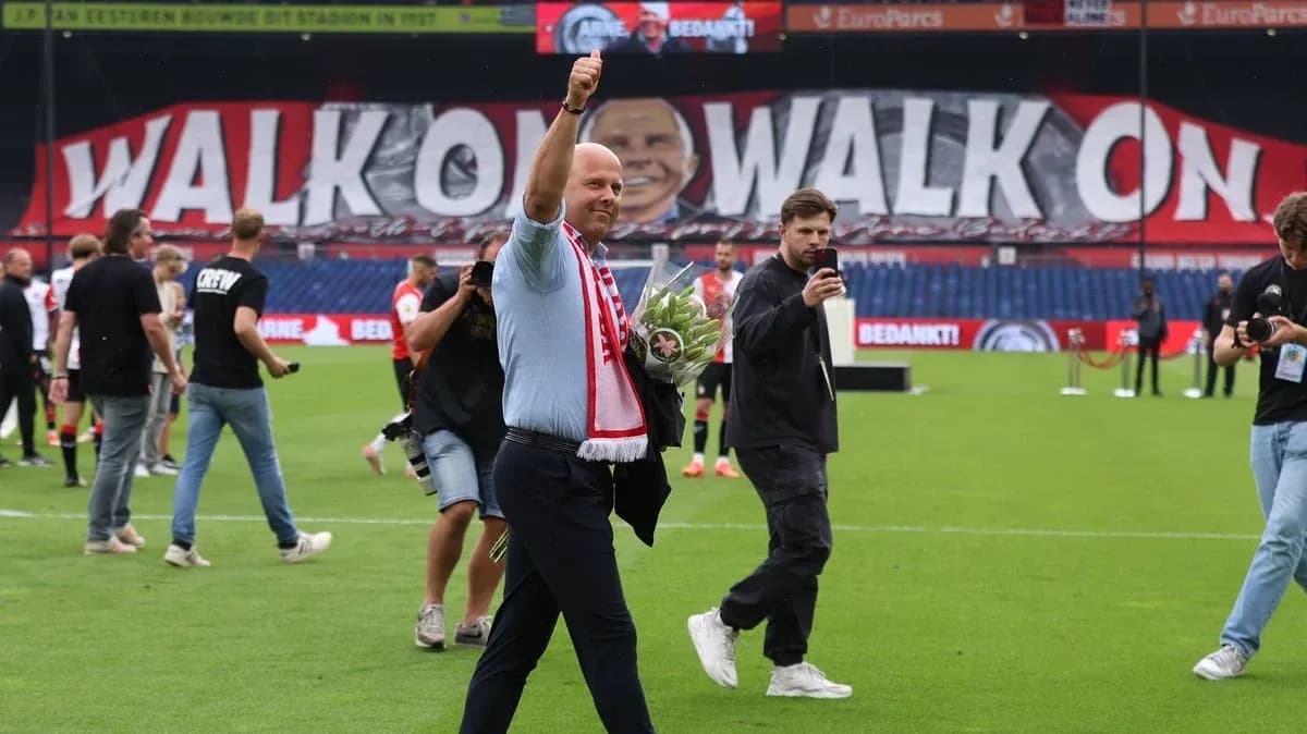 Director saludando con ramo en el campo de fútbol