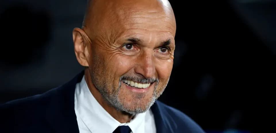 Hombre sonriendo con traje en evento deportivo