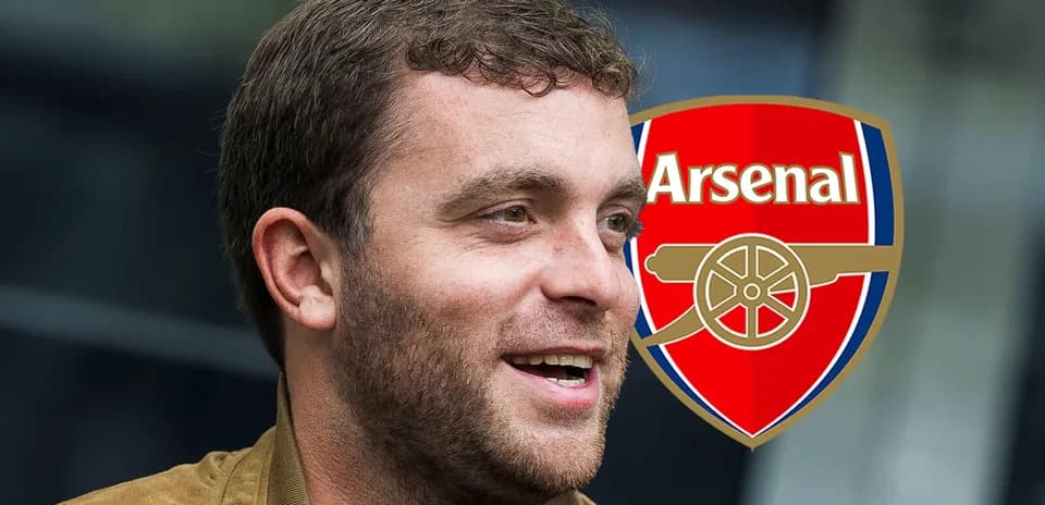 Hombre sonriendo junto al logo de Arsenal