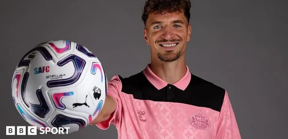 Jugador sosteniendo balón de fútbol en estudio