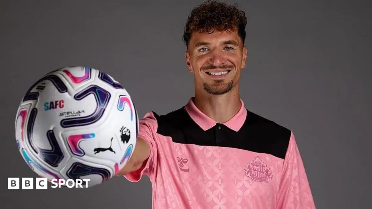 Jugador sosteniendo balón de fútbol en estudio