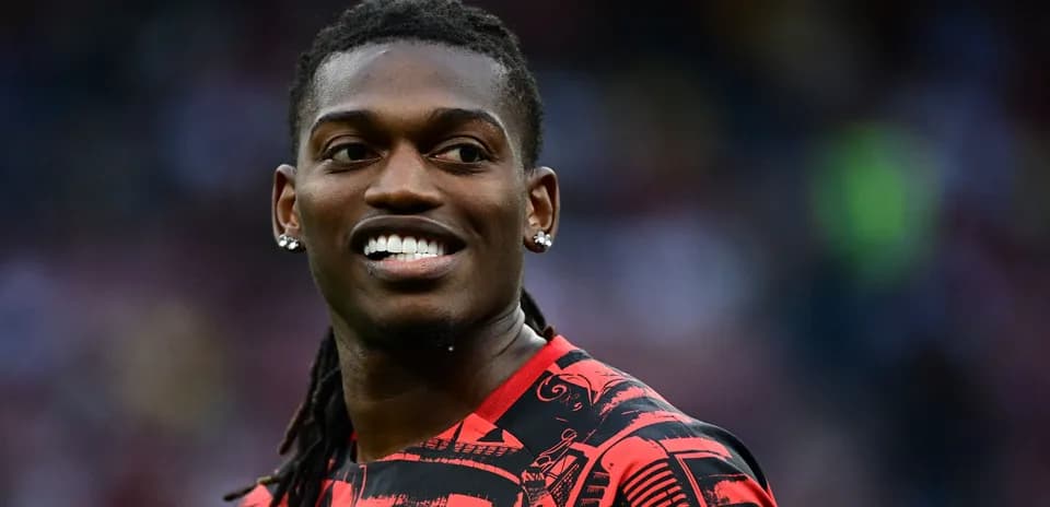 Jugador sonriente con camiseta roja en el campo