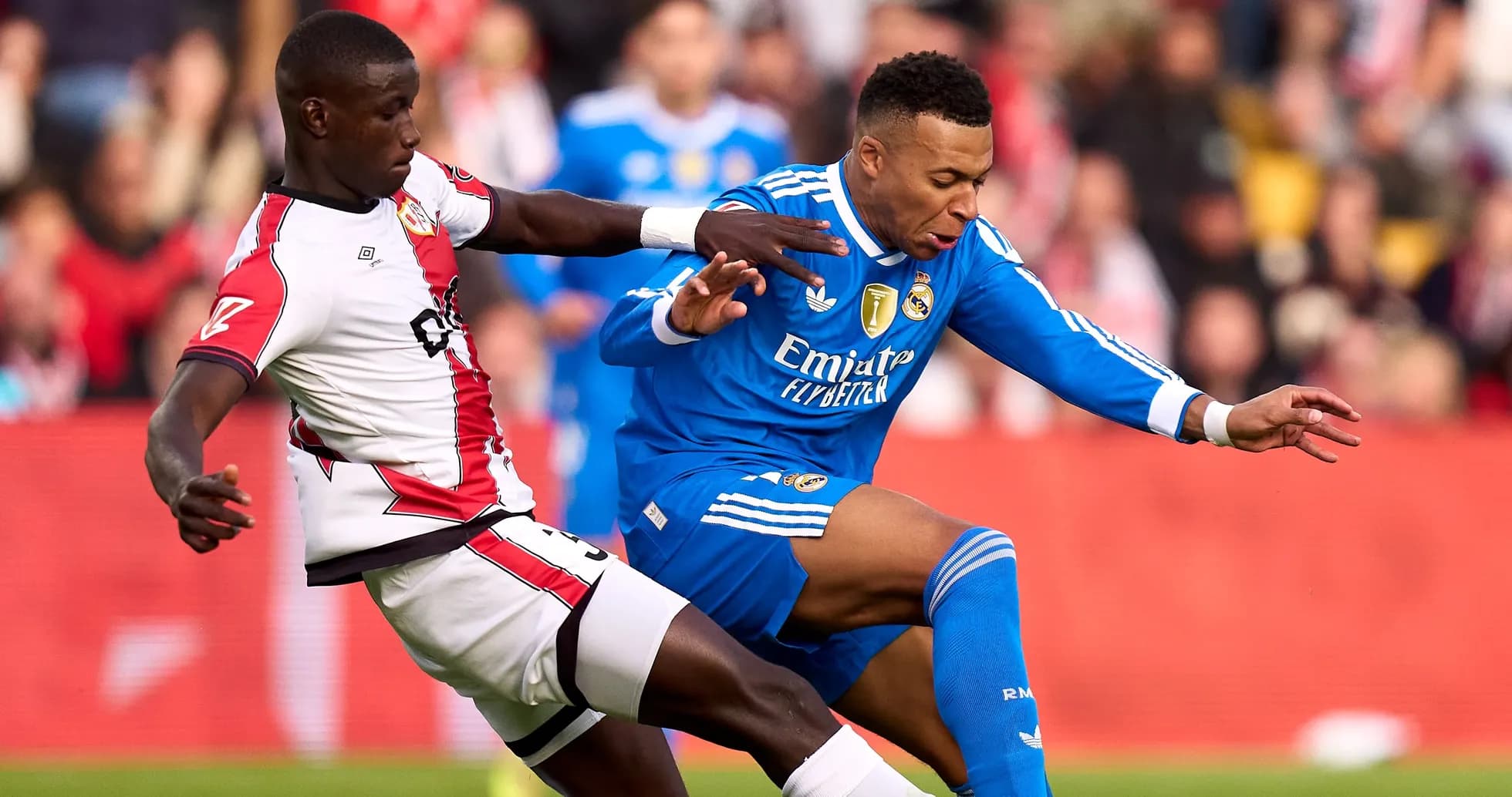 Jugador de Real Madrid siendo derribado por oponente