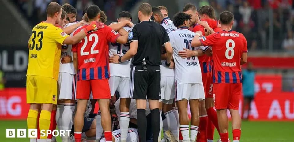 Jugadores de ambos equipos en un círculo durante el partido