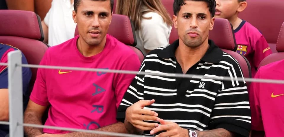 Dos jugadores sentados en el estadio viendo el partido