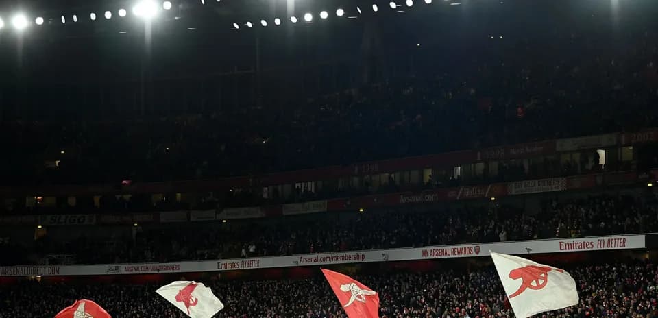 Aficionados de Arsenal ondeando banderas en el estadio