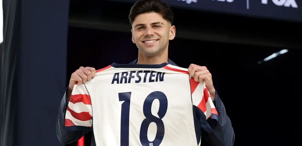 Jugador sosteniendo camiseta con nombre Arfsten y número 18
