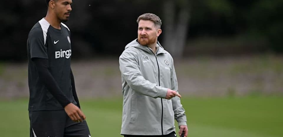 Jugador y entrenador conversando durante entrenamiento
