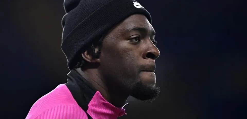 Jugador en calentamiento con chaqueta rosa y gorro
