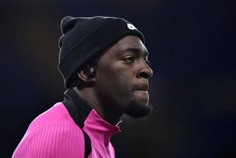 Jugador en calentamiento con chaqueta rosa y gorro