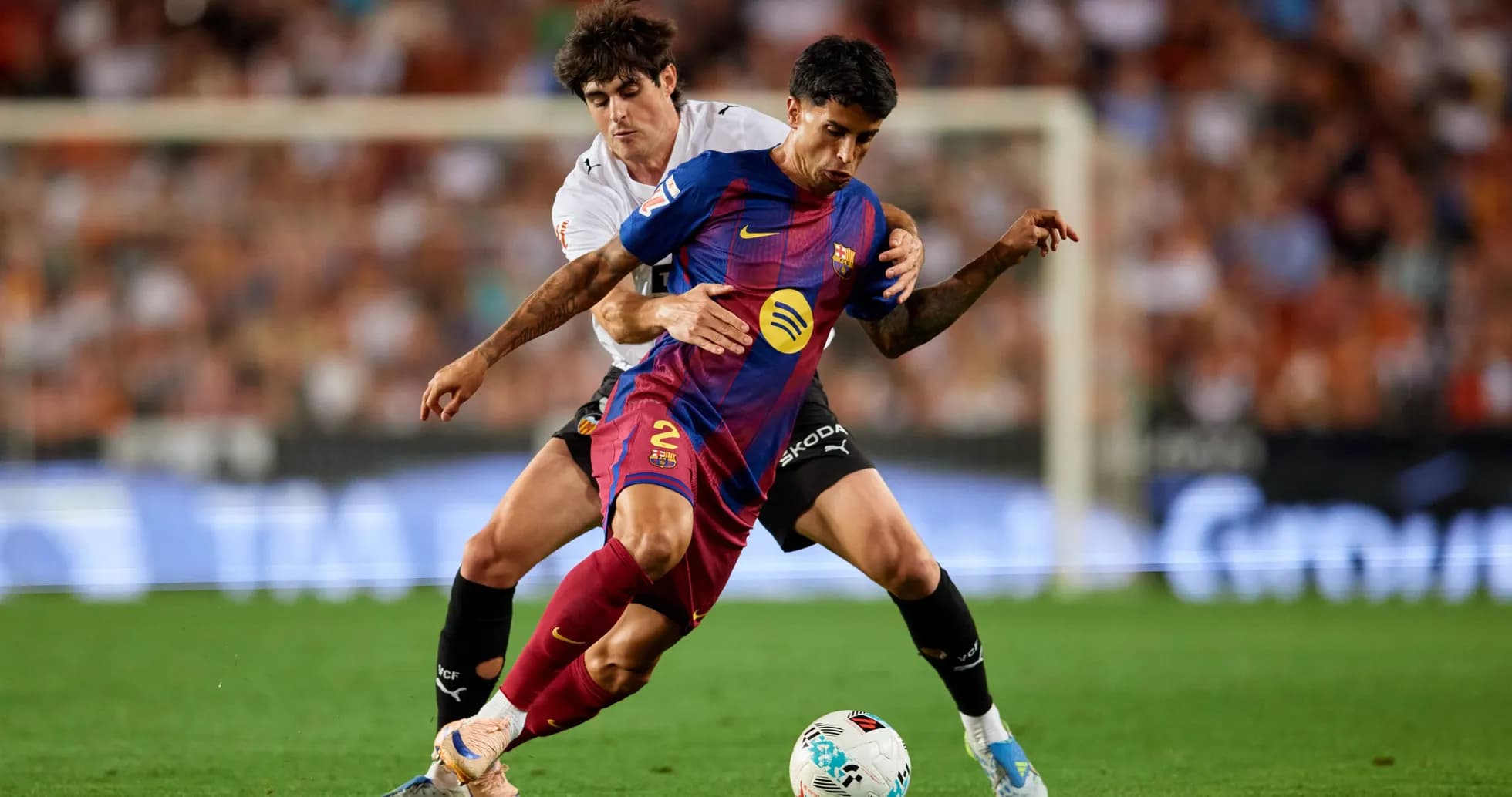 Jugador del Barcelona siendo marcado por rival