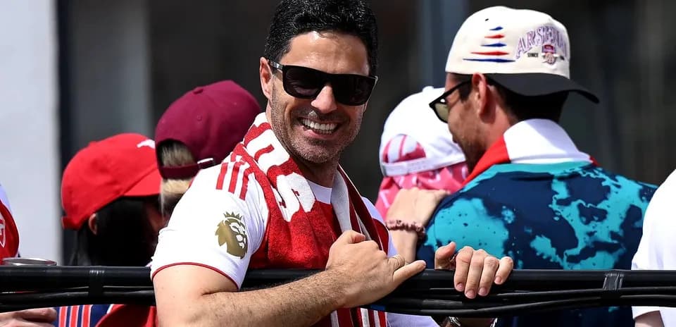 Hombre sonriendo con bufanda en un evento deportivo