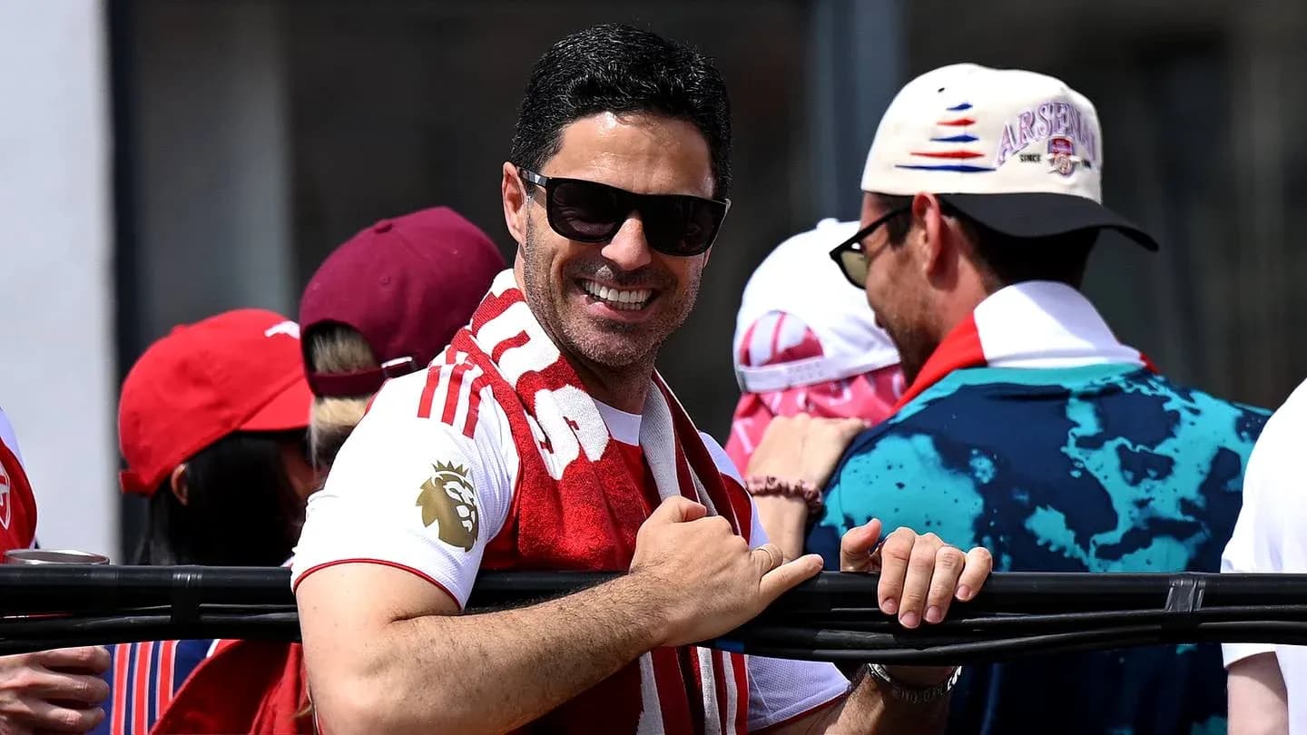 Hombre sonriendo con bufanda en un evento deportivo