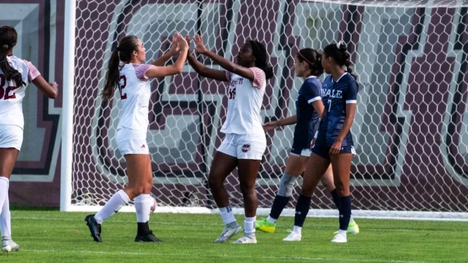 Jugadoras celebrando un gol en el campo de fútbol