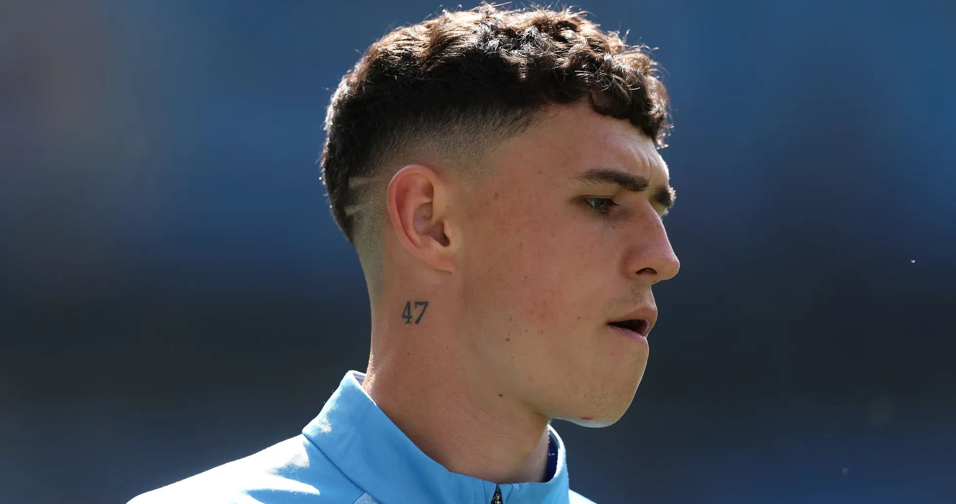 Jugador con camiseta azul y tatuaje en el cuello