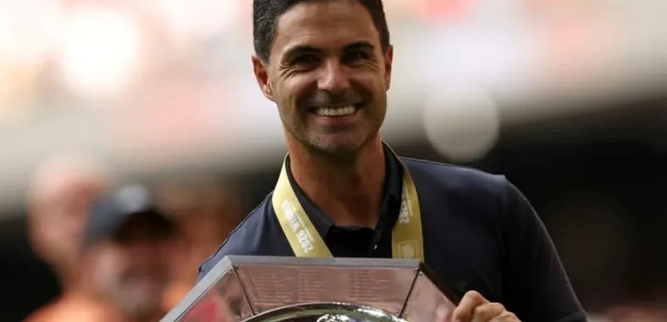 Entrenador sosteniendo trofeo durante celebración